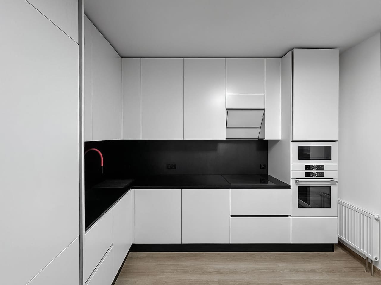Угловая кухня белого цвета с черной столешницей